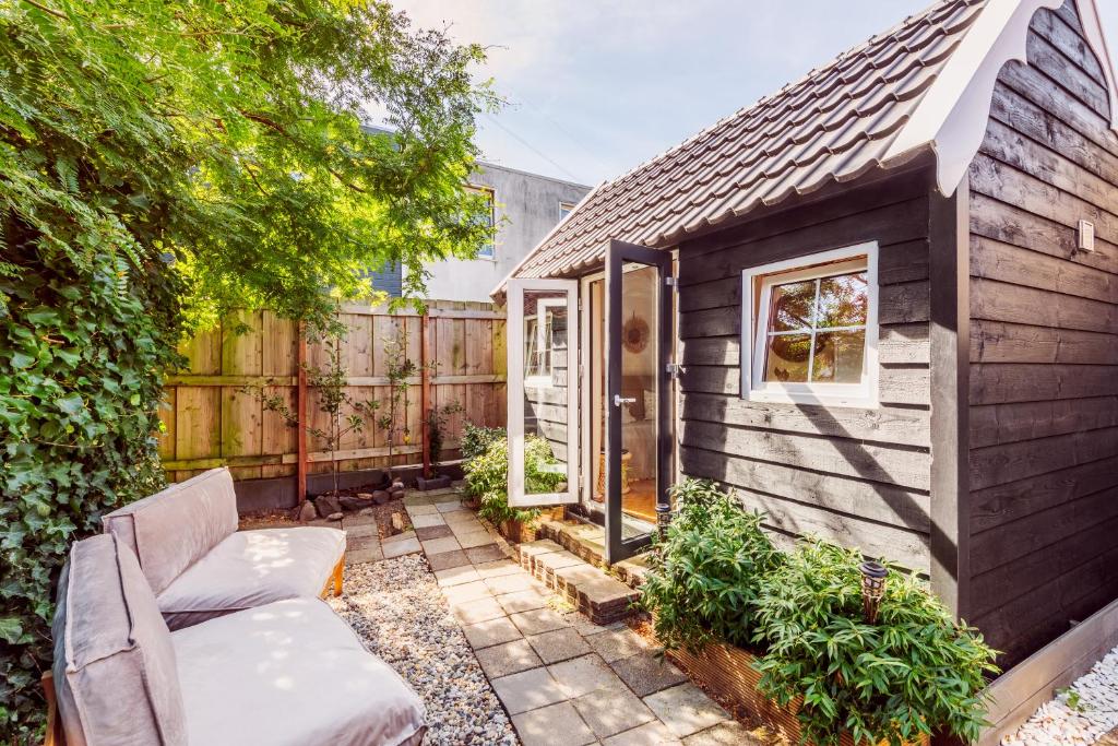 a tiny house with a patio and a fence at Tiny house Zaandam in Zaandam
