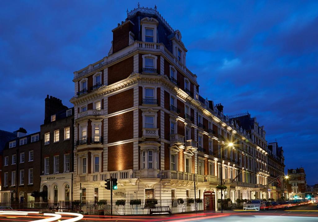 فندق ذا مانديفيل في لندن: مبنى كبير على شارع المدينة ليلا