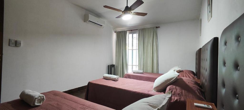 a bedroom with two beds and a ceiling fan at Departamento Bienestar Termas in Federación