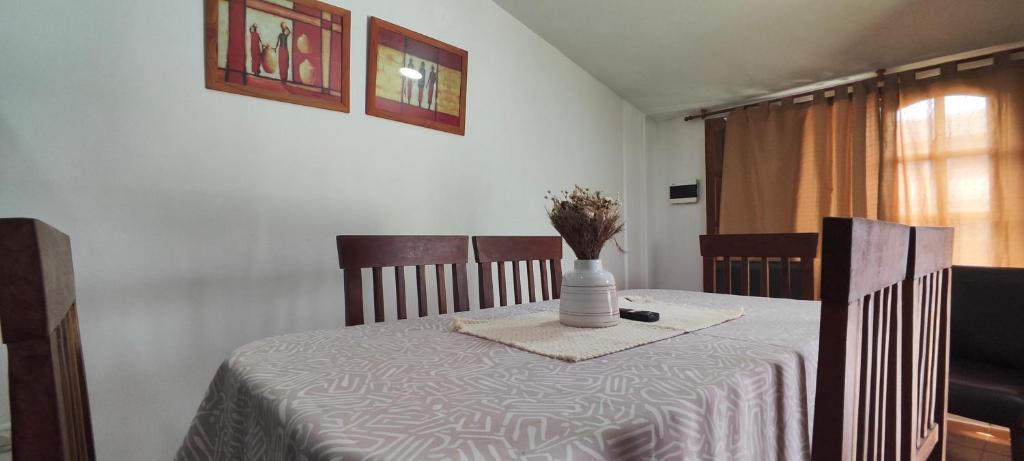 a table with a vase of flowers on top of it at Departamento Bienestar Termas in Federación