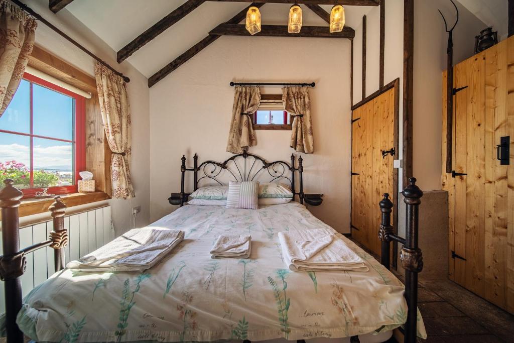 una camera da letto con un letto grande con asciugamani sopra di Geraghtys Farmyard Pods a Mayo