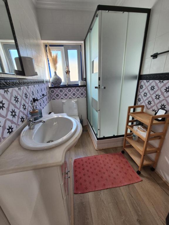 a bathroom with a sink and a glass shower at Villa Alegria in Ericeira