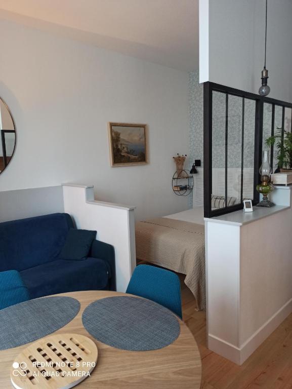 - un salon avec une table, un canapé et un lit dans l'établissement Studio centre ville, à Les Sables-dʼOlonne