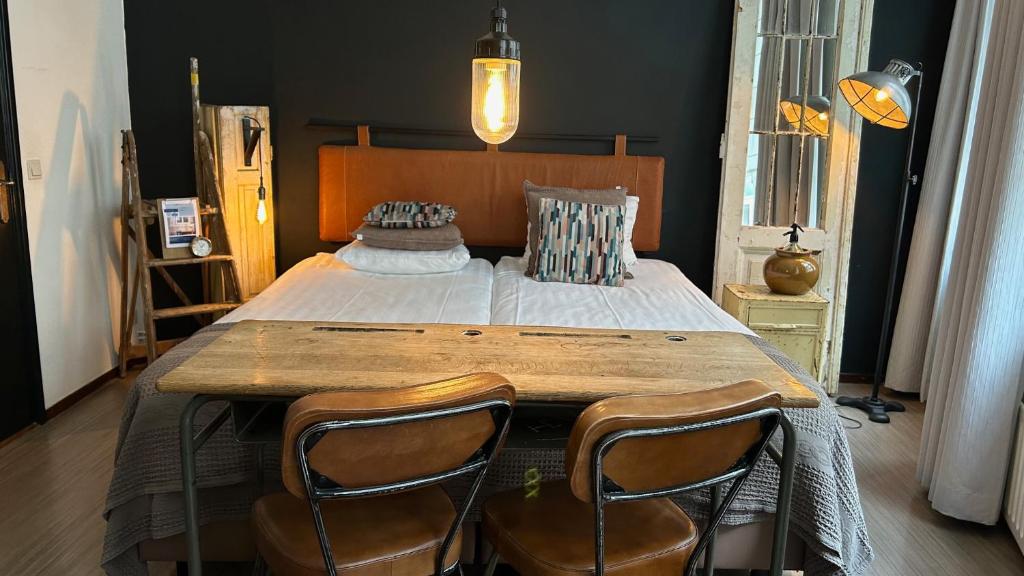 - une chambre avec un grand lit et 2 chaises dans l'établissement BE41 Boutique Hotel, à Maastricht