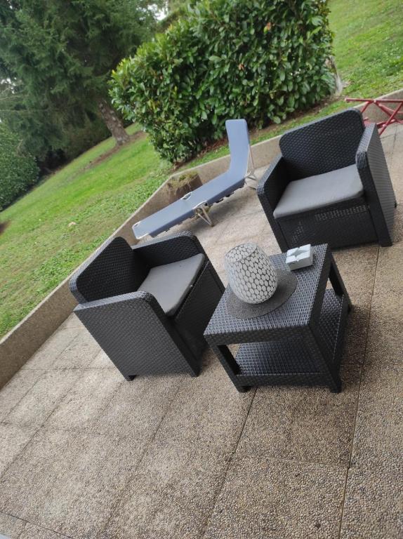 deux chaises et une table sur une terrasse dans l'établissement Très bel appartement 3 pièces + jardin + parking, à Divonne-les-Bains