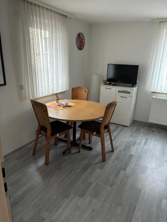 a dining room table with two chairs and a television at Ferienwohnung für vier Personen in Helmstadt