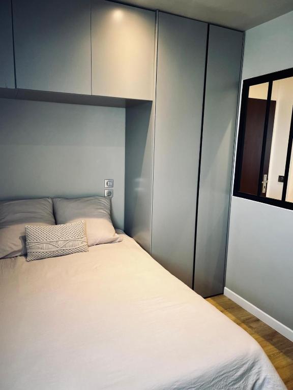 une chambre avec un lit blanc et une fenêtre dans l'établissement Appartement confortable à port cergy, à Cergy