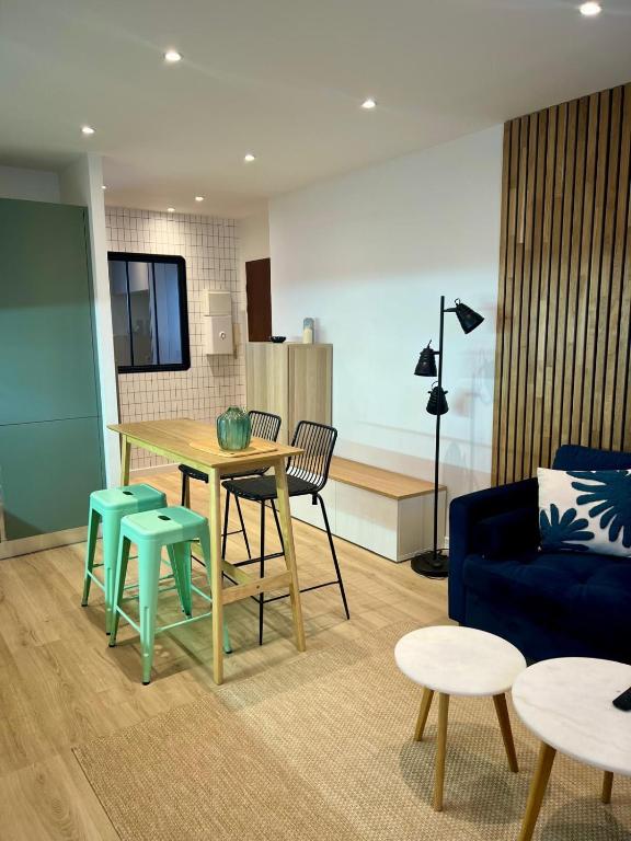 ein Wohnzimmer mit Tisch und Stühlen und einer Couch in der Unterkunft Appartement design et cozy à port cergy in Cergy