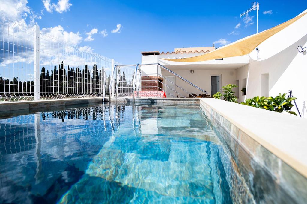una piscina davanti a una casa di La caseta de cinta a El Lligallo del Gànguil