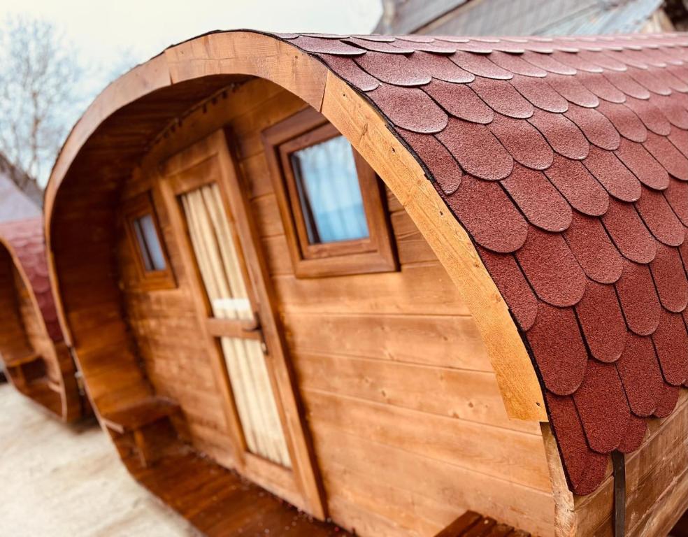 a wooden hobbit house with a door and a roof at Casa Ale in Roşia Montană