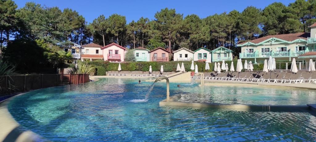 une piscine avec toboggan en face des maisons dans l'établissement Au milieu des pins, charmant appartement de 38 m2 - 4 personnes - Domaine du Golf, à Lacanau-Océan