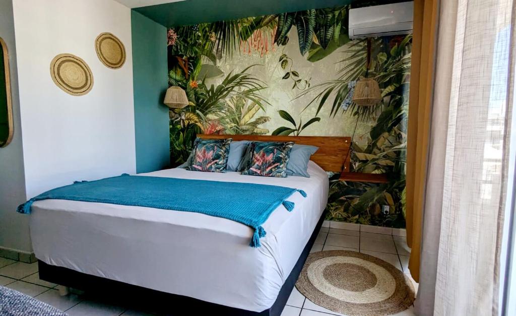 a bedroom with a bed in a room with plants at Le Papangue, instant exotique in Saint-Pierre