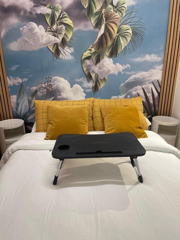 - une chambre avec un lit orné d'une fresque murale représentant des plantes dans l'établissement Le Loft Bleu La Madeleine - un mini loft design et très central, à Paris