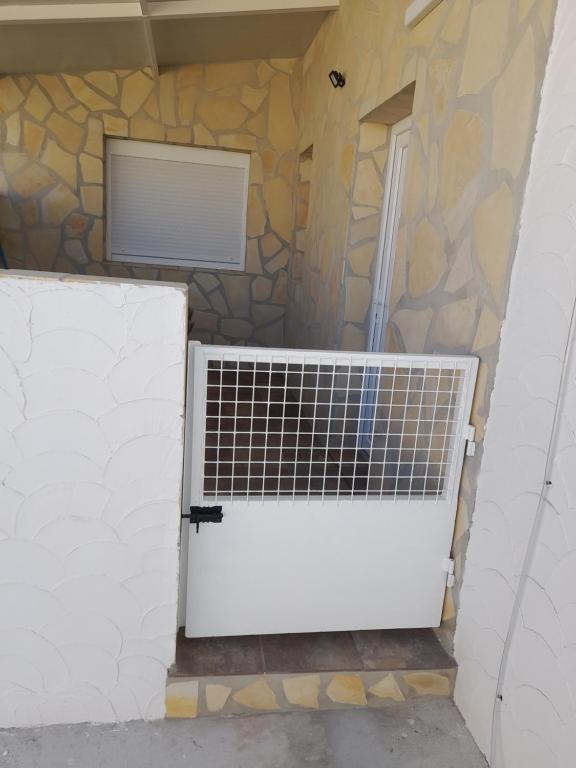 garaż z białymi drzwiami i kamienną ścianą w obiekcie LA ERA 30 w mieście Bolonia
