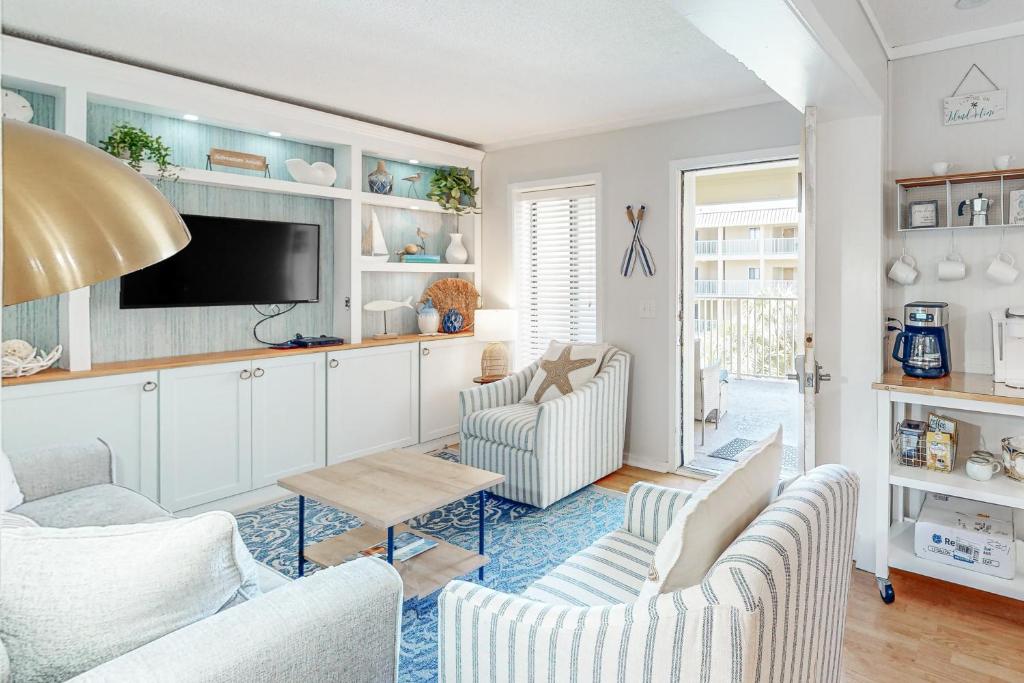 a living room with two chairs and a tv at Hilton Head Resort 2301 in Hilton Head Island