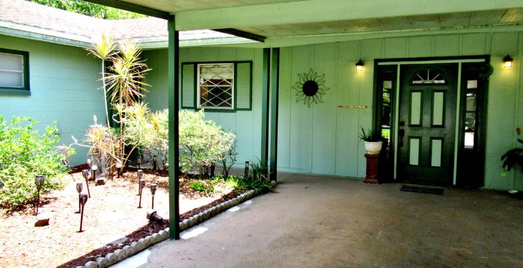 a green house with a black door and a yard at Eric and Nancy's Boutique Bed and Breakfast in Tampa