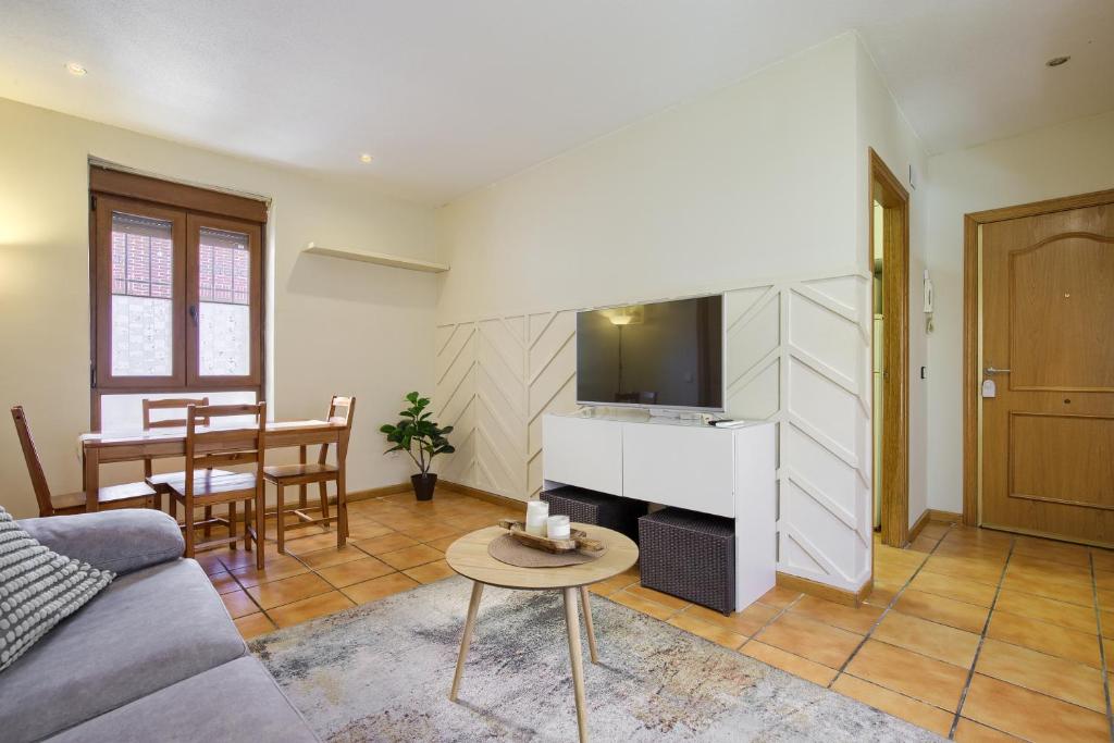 a living room with a couch and a tv at CASONA 44 - Apartamento para 2 con Wifi, AC y Patio Exterior in Alcalá de Henares