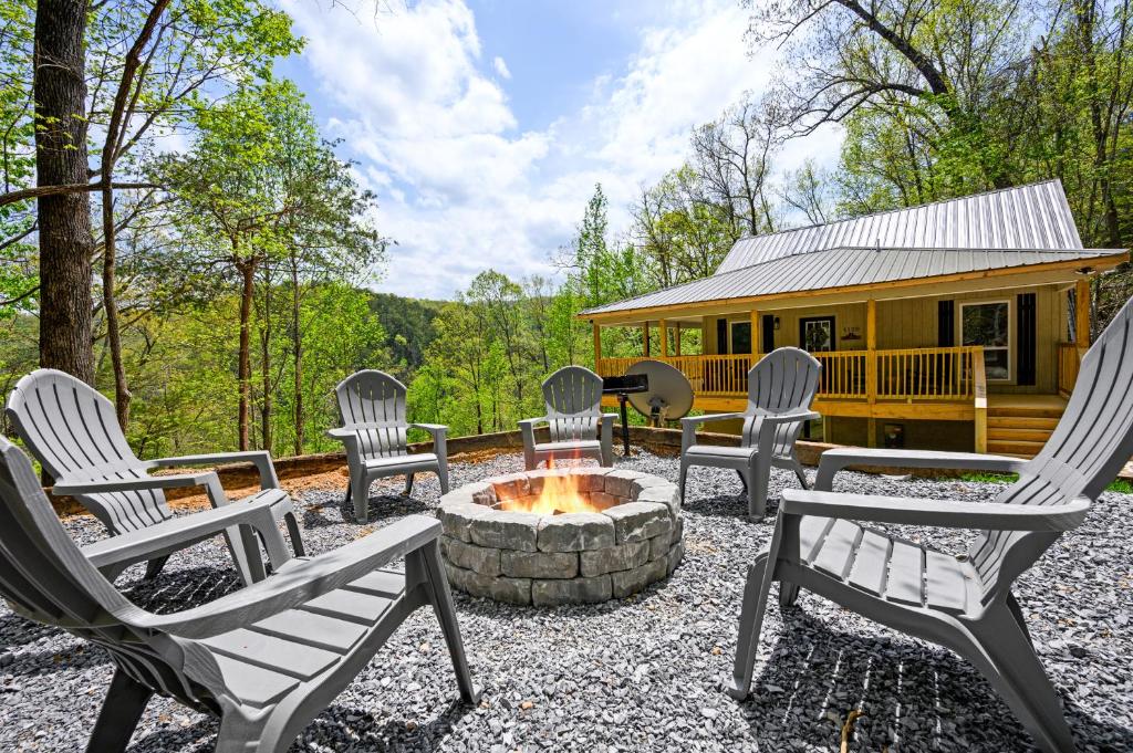 a group of chairs sitting around a fire pit in front of a cabin at Lazy Bear in Sevierville