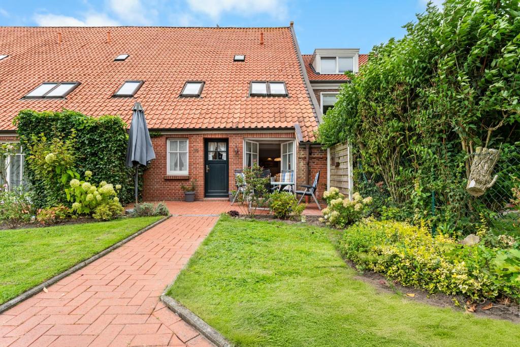 a brick house with a brick pathway leading to the front door at Ferienwohnung Nordlicht in Greetsiel