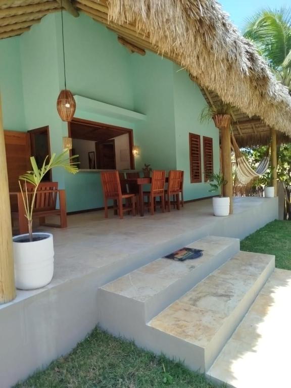 a house with a patio with a table and chairs at Casa da Lagoa - Pousada Icaraí Kite Village in Amontada