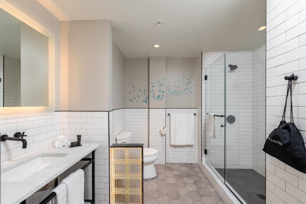 a bathroom with a toilet and a glass shower at voco James Newbury Hudson Valley by IHG in Coxsackie