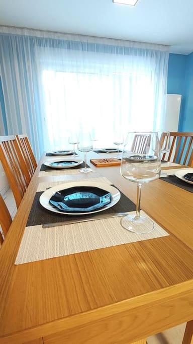 - une table à manger avec une assiette et des verres à vin dans l'établissement Maison spacieuse à Morsang sur Orge, idéale pour 8, à Morsang-sur-Orge