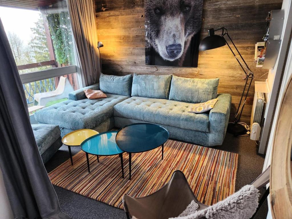 un salon avec un canapé bleu et deux tables dans l'établissement Résidence Thuria - Spacieux 3 pièces 7/8 personnes MAE-4654, à Arc 1800