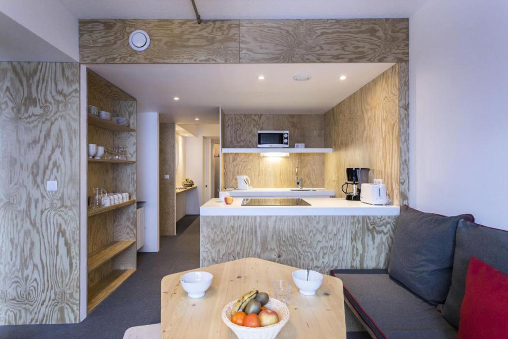 une cuisine avec une table avec un bol de fruits dessus dans l'établissement Résidence Aiguille Rouge - Centre station Appartement 3 pièces 8 personnes MAE-4634, à Arc 2000