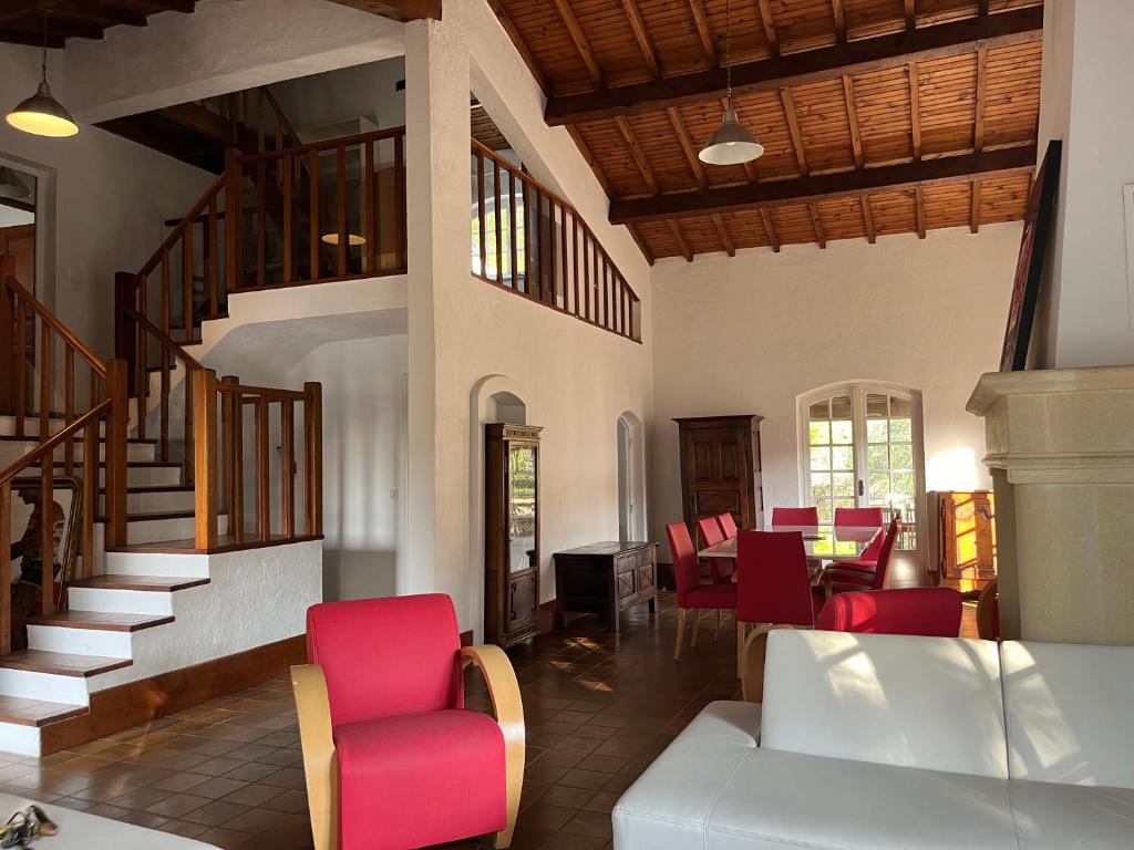 - un salon avec des chaises rouges et un escalier dans l'établissement Maison 10 couchages, 5km des plages, 12km de Montpellier, à Pérols