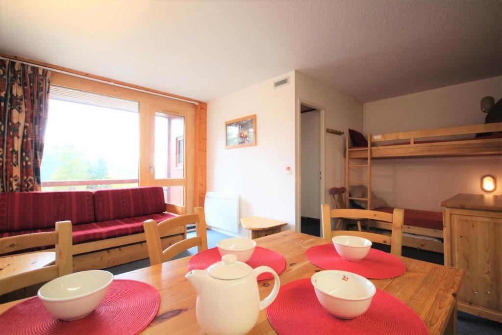 d'un salon avec une table recouverte de plaques rouges dans l'établissement Résidence Armoise - Deux pièces 6 personnes centre station MAE-4854, à Arc 1800