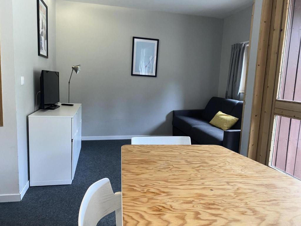 - un salon avec une table, une télévision et un canapé dans l'établissement Résidence Thuria - Charmant 2 pièces 5 personnes MAE-4994, à Arc 1800