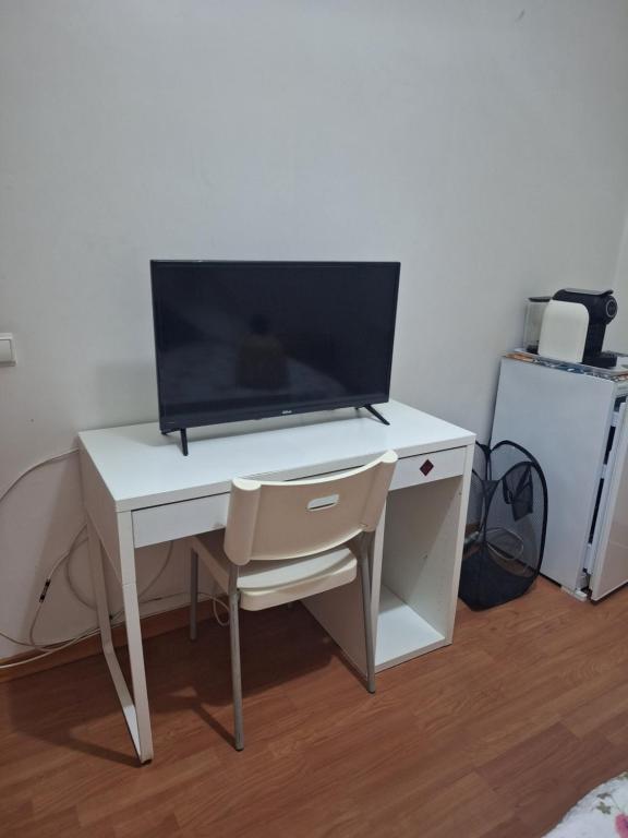 a white desk with a tv on top of it at House Prosperity in Amora