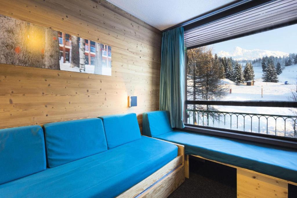 Cette chambre dispose d'un canapé et d'une grande fenêtre. dans l'établissement Résidence Lauzieres - Studio 5 personnes pied des pistes MAE-5244, à Arc 1800