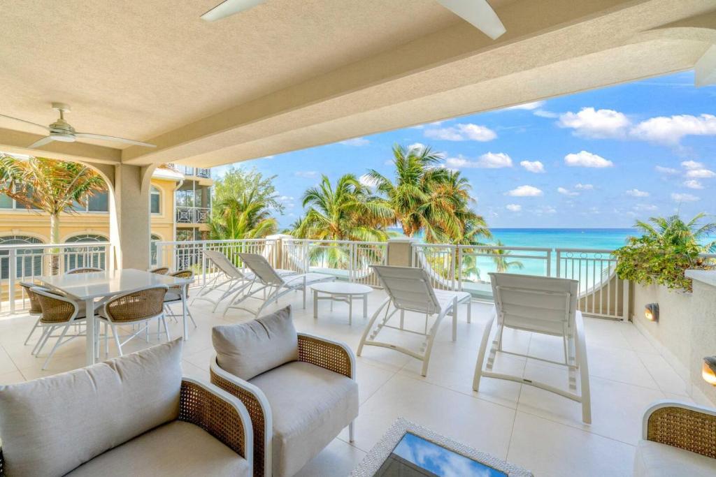 ジョージ・タウンにあるBeachcomber 11のテーブルと椅子と海のあるバルコニー