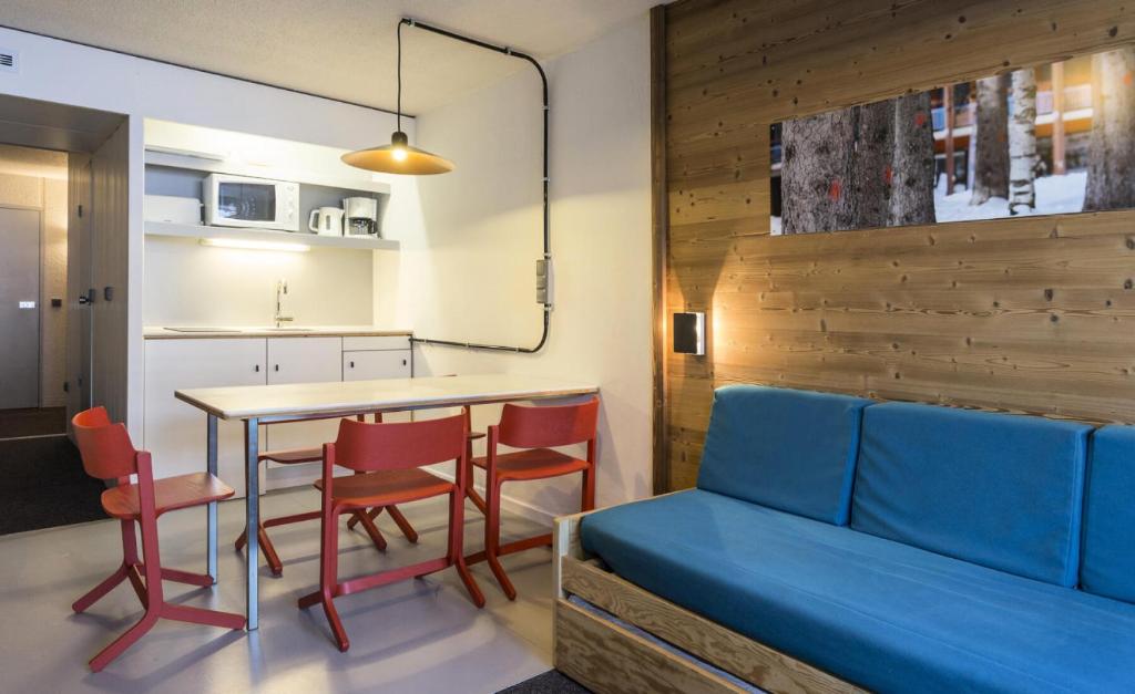 un salon avec un canapé bleu, une table et des chaises dans l'établissement Résidence Lauzieres - Studio 5 personnes pied des pistes MAE-5274, à Arc 1800