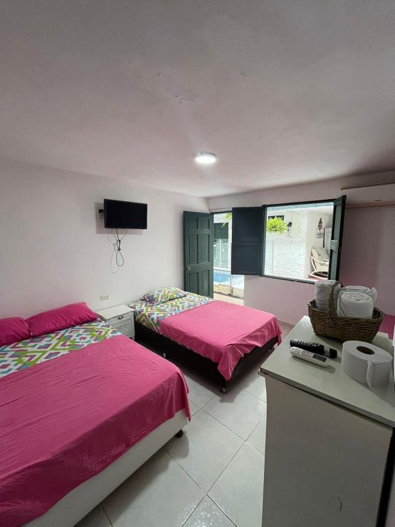 a bedroom with two beds and a flat screen tv at CASA FLOR DE LIZ in Villavieja
