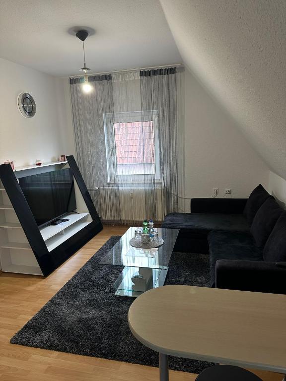 a living room with a black couch and a table at Hammer Wohnung in Hamm