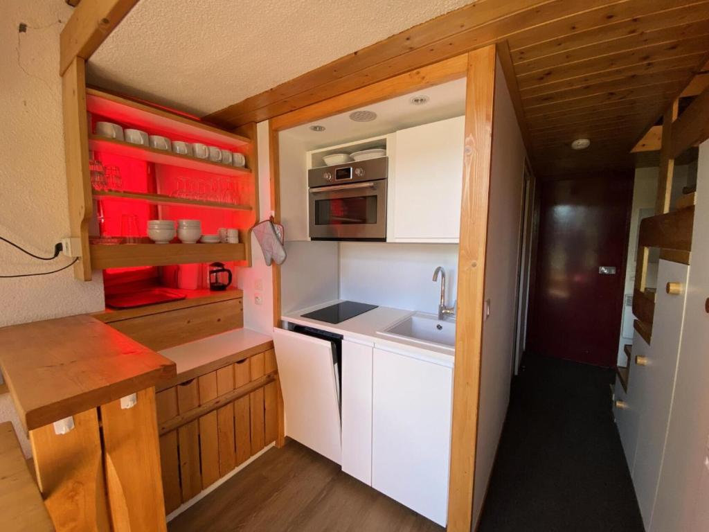 une petite cuisine avec des armoires blanches et un évier dans l'établissement Résidence Mirantins 3 - Studio mezzanine 4 personnes proche Transarc MAE-6084, à Arc 1800