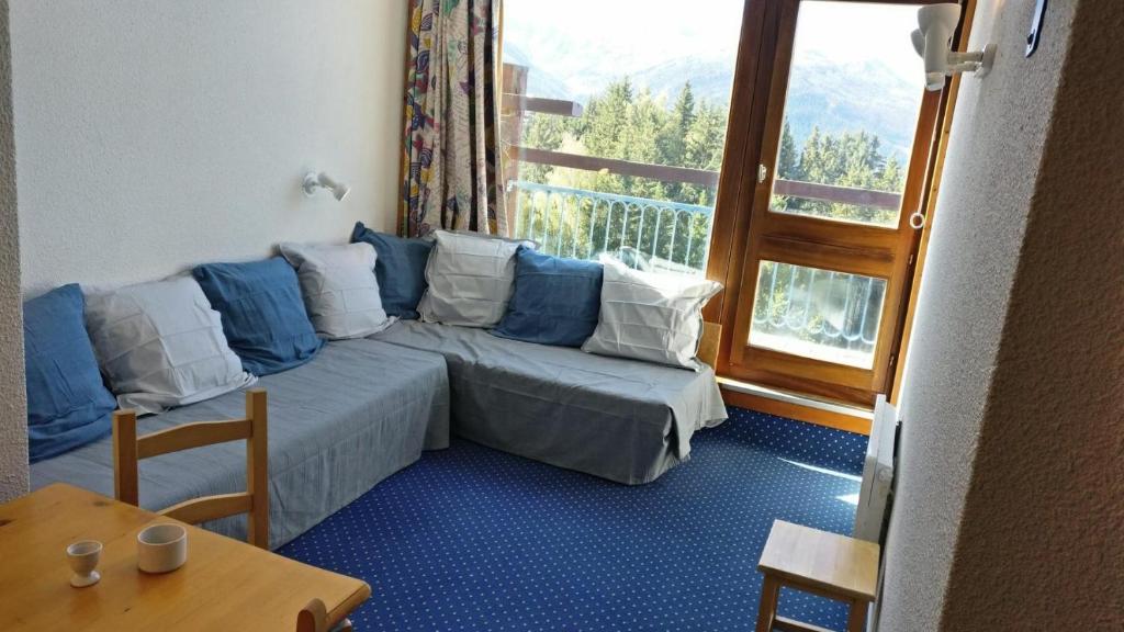 un salon avec un canapé et une grande fenêtre dans l'établissement Résidence Belles Challes - Studio 4 personnes pied des pistes MAE-6144, à Arc 1800