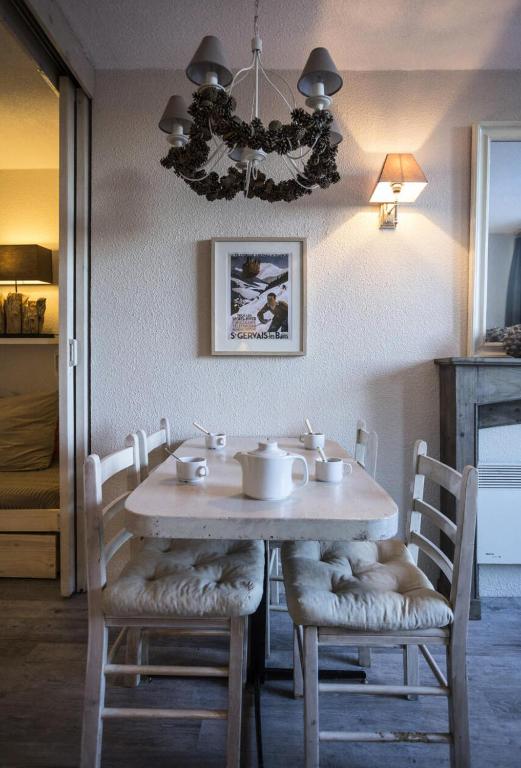 une table à manger avec des chaises et un lustre dans l'établissement Résidence Belles Challes - Studio 4 personnes pied des pistes MAE-6174, à Arc 1800