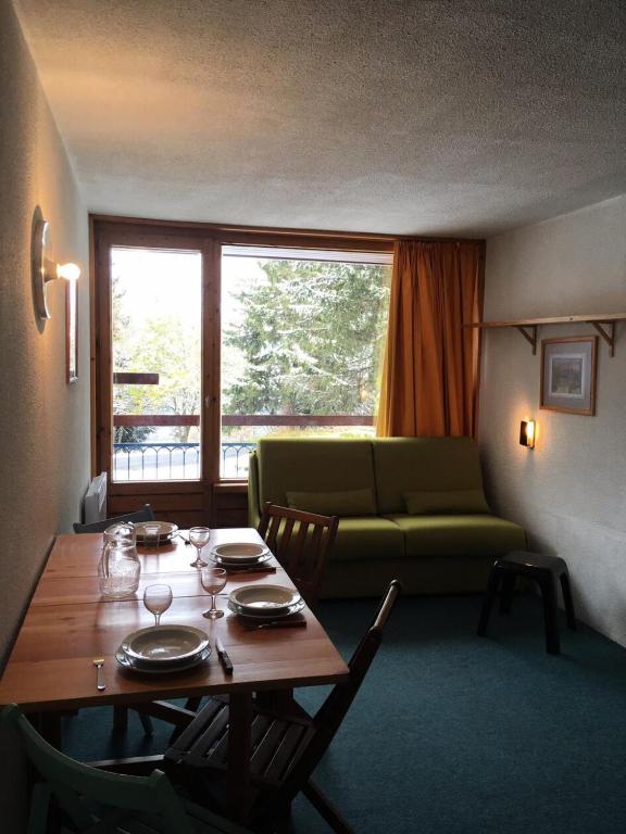 - un salon avec une table et un canapé vert dans l'établissement Résidence Lauzieres - Studio 5 personnes pied des pistes MAE-6394, à Arc 1800
