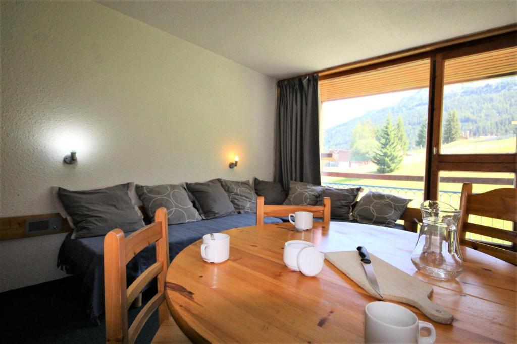un salon avec une table en bois et un canapé dans l'établissement Résidence Pierra Menta - Studio 5 personnes centre station MAE-6404, à Arc 1800