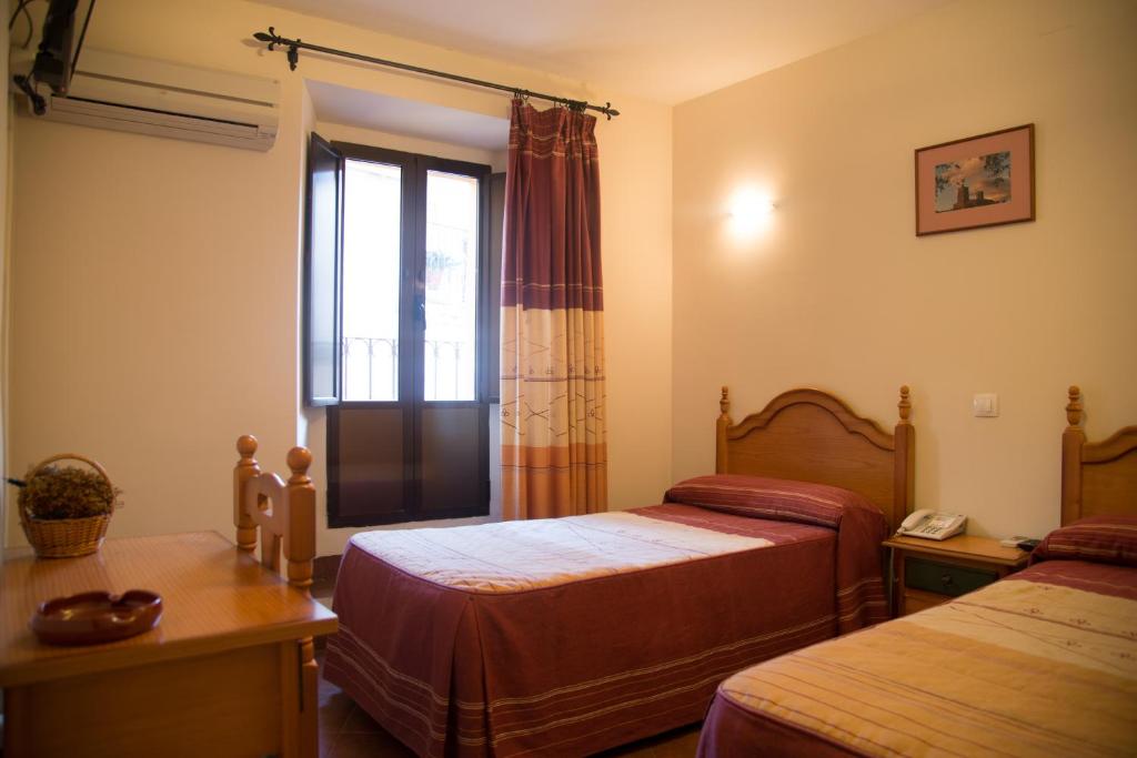 A bed or beds in a room at Hostal Hueso