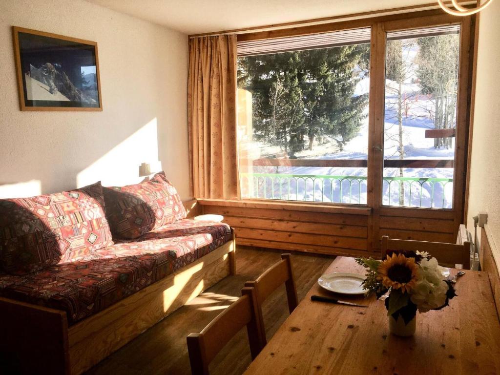 un salon avec un canapé, une table et une fenêtre dans l'établissement Résidence Lauzieres - Studio 5 personnes pied des pistes MAE-6434, à Arc 1800