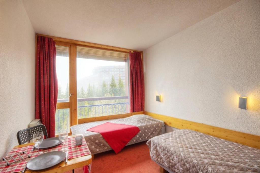 une chambre d'hôtel avec deux lits et une fenêtre dans l'établissement Résidence Grand Arbois - Studio 2 personnes centre station MAE-6594, à Arc 1800