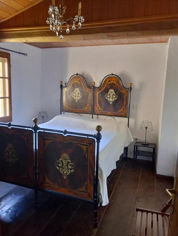 a bedroom with a wooden bed with white sheets at Tabernacolo in Carpineta