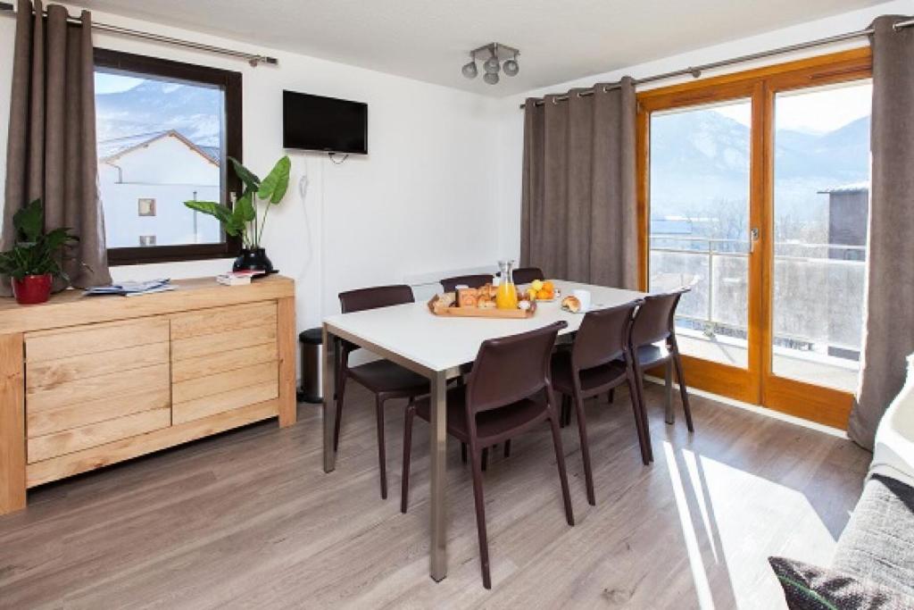 une salle à manger avec une table et des chaises dans l'établissement Résidence Signal Du Prorel - Appartement entièrement rénové · Au pied des pistes · Casier à skis & wifi gratuit MAE-0454, à Briançon