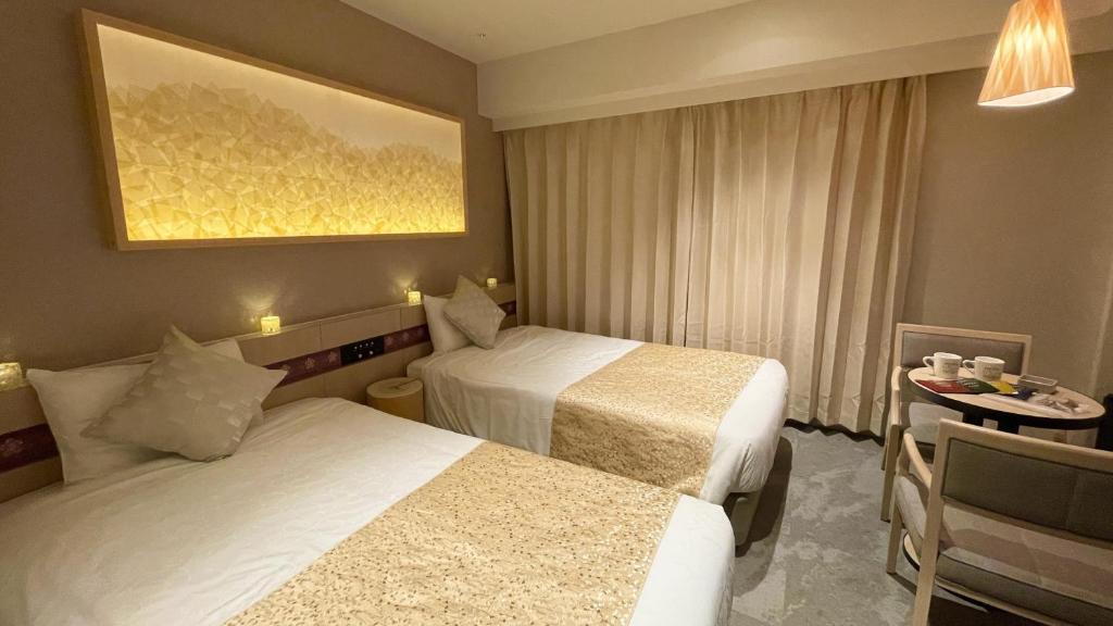 a hotel room with two beds and a table at Henn na Hotel Premier Nara in Nara