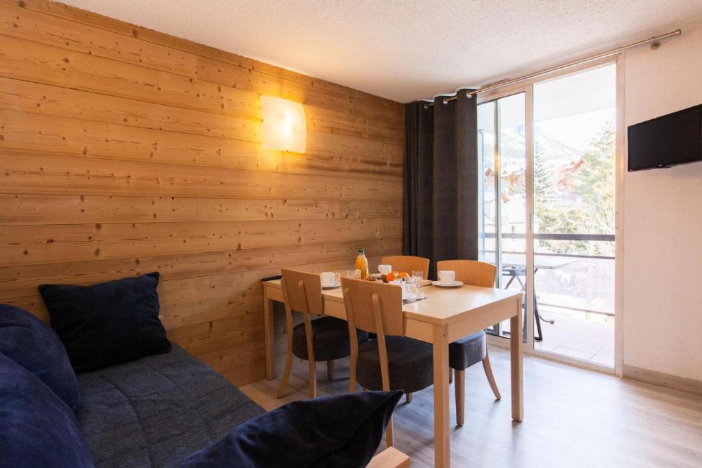 une salle à manger avec une table et une chambre avec une fenêtre dans l'établissement Résidence Relais De La Guisane - Appartement rénové & lumineux · Au pied des pistes · Casier à skis MAE-0564, à Briançon