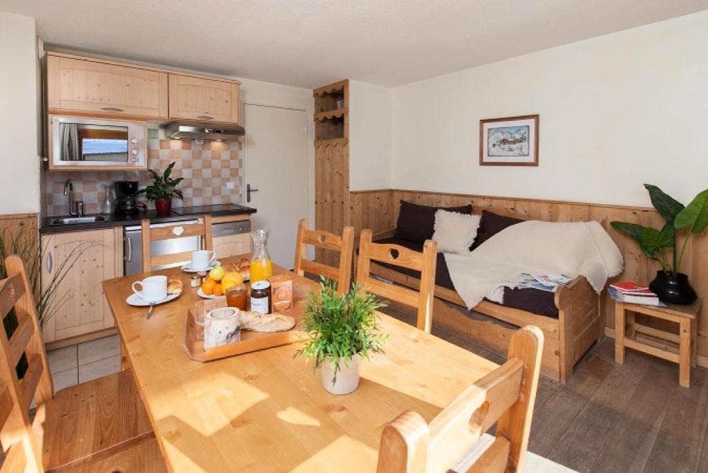 Il comprend une cuisine et un salon avec une table en bois. dans l'établissement Résidence Signal Du Prorel - Studio lumineux · Au pied des pistes · Wifi gratuit & casier à skis MAE-0644, à Briançon